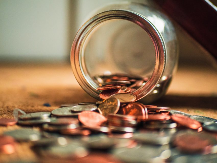 Photo of coins spilling out of a jar, by Josh Appel on Unsplash